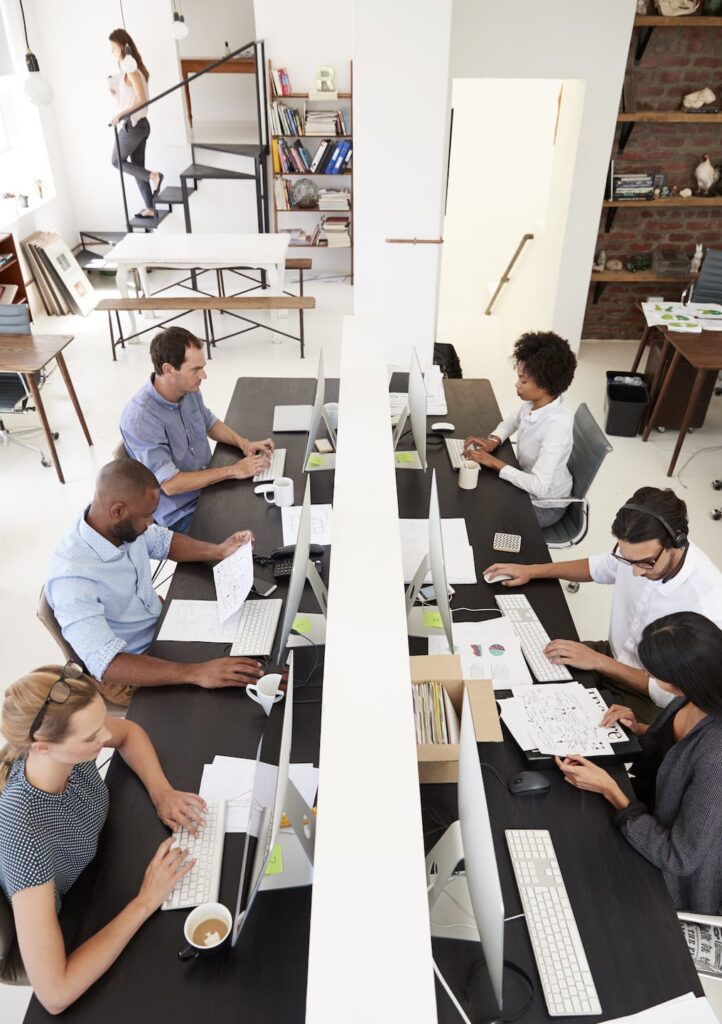 colleagues working at a busy open plan office PQMUBW3 1